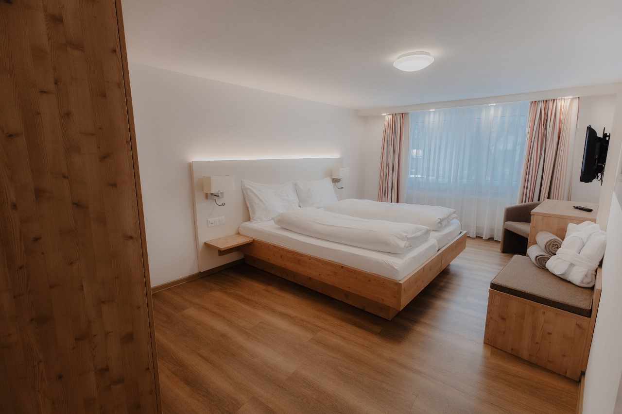 Elegant and spacious hotel room at Hotel Grächerhof, perfect for a Swiss Alps getaway